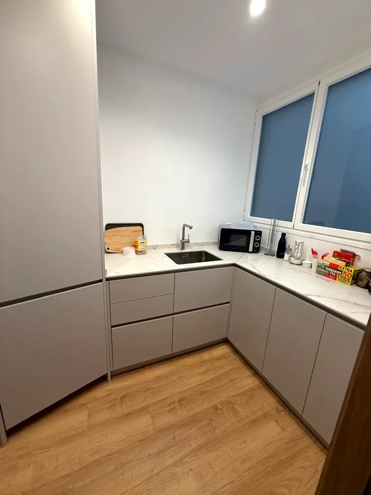 Cocina funcional en gris claro junto a ventana